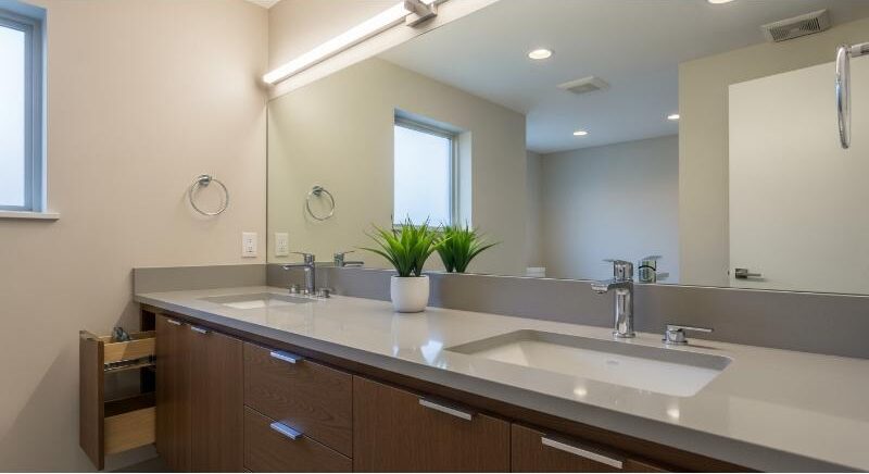 Double vanity with quartz countertop and storage solutions in a modern South Congress Austin bathroom.